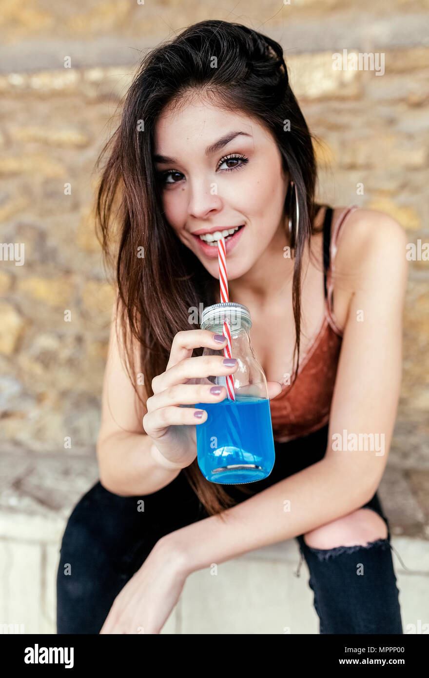 Porträt eines lächelnden brünette Frau trinkt Blaue Limonade Stockfoto