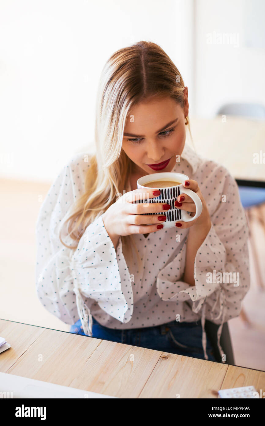 Junge Frau arbeitet im Büro, Pause machen, Kaffee trinken Stockfoto