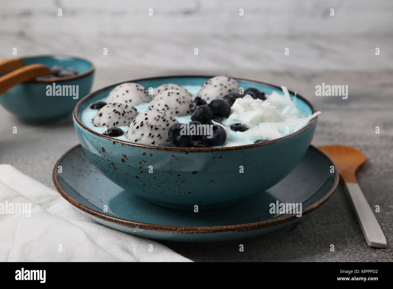 Blau smoothie Schüssel mit Kokosraspeln, Blaubeeren und Drachenfrucht Kugeln Stockfoto