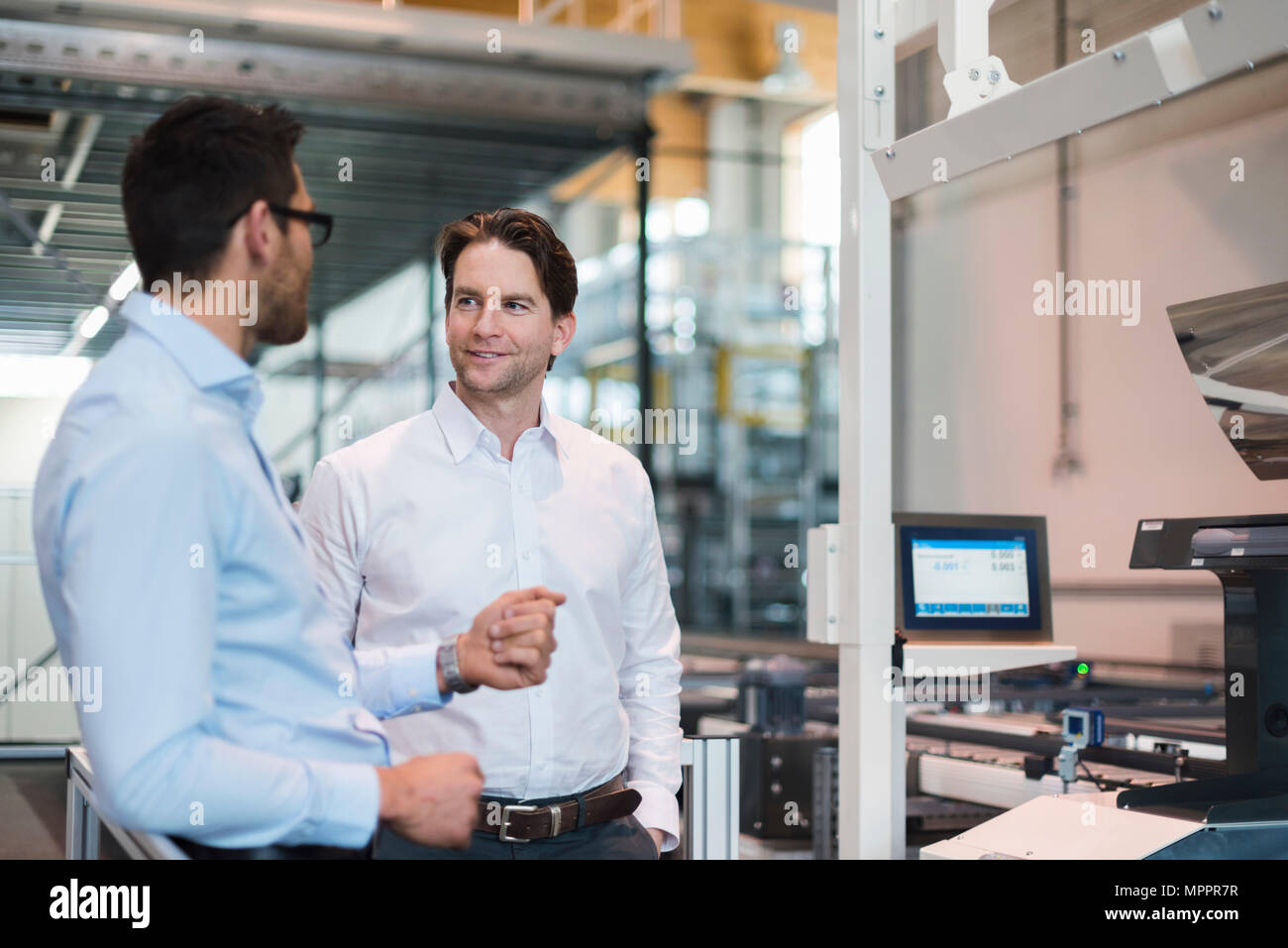Zwei Geschäftsleute sprechen in der modernen Fabrik Stockfoto
