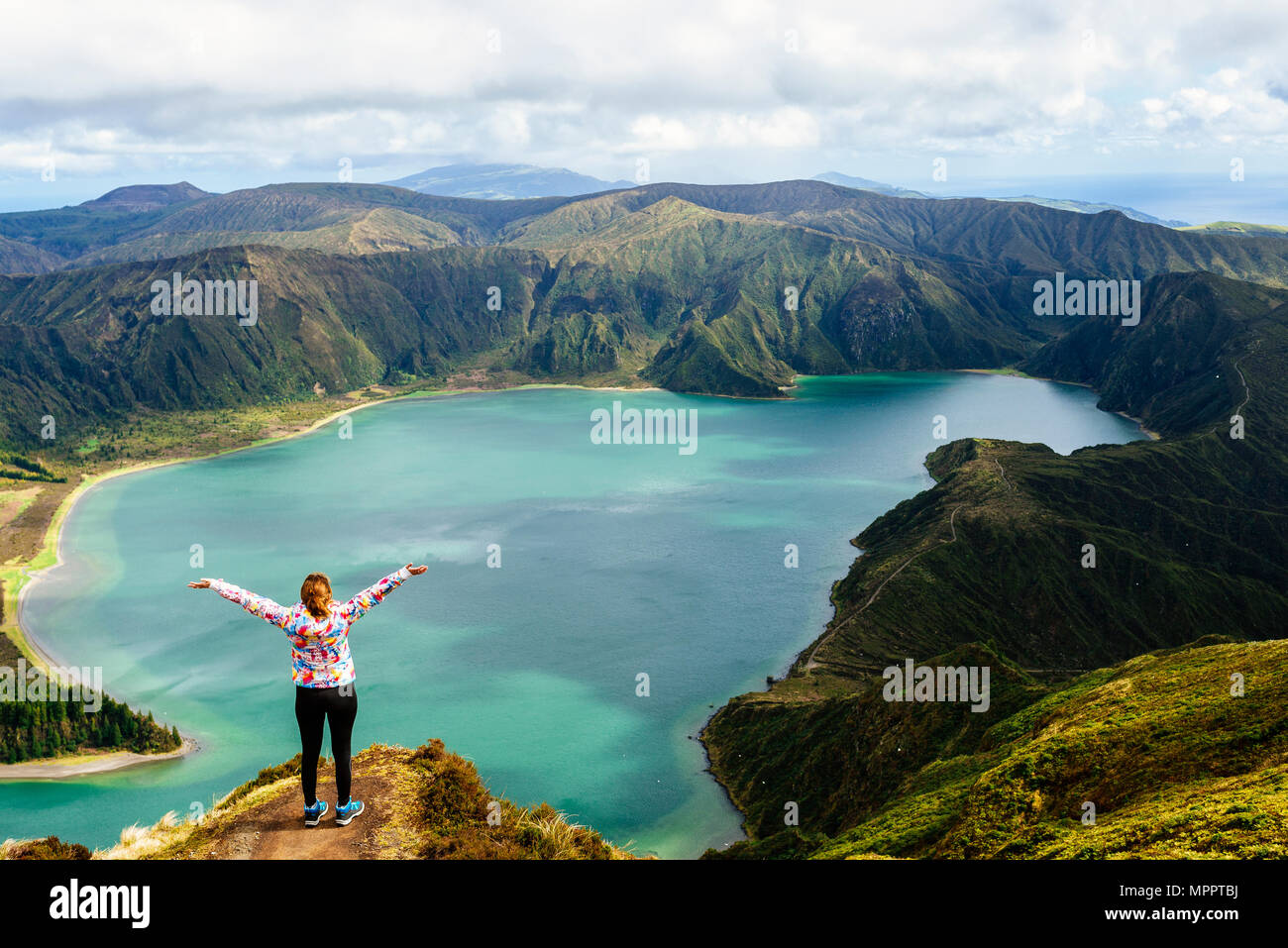 Azoren, Sao Miguel, Frau mit erhobenen Armen auf der Oberseite der Lagoa do Fogo Stockfoto