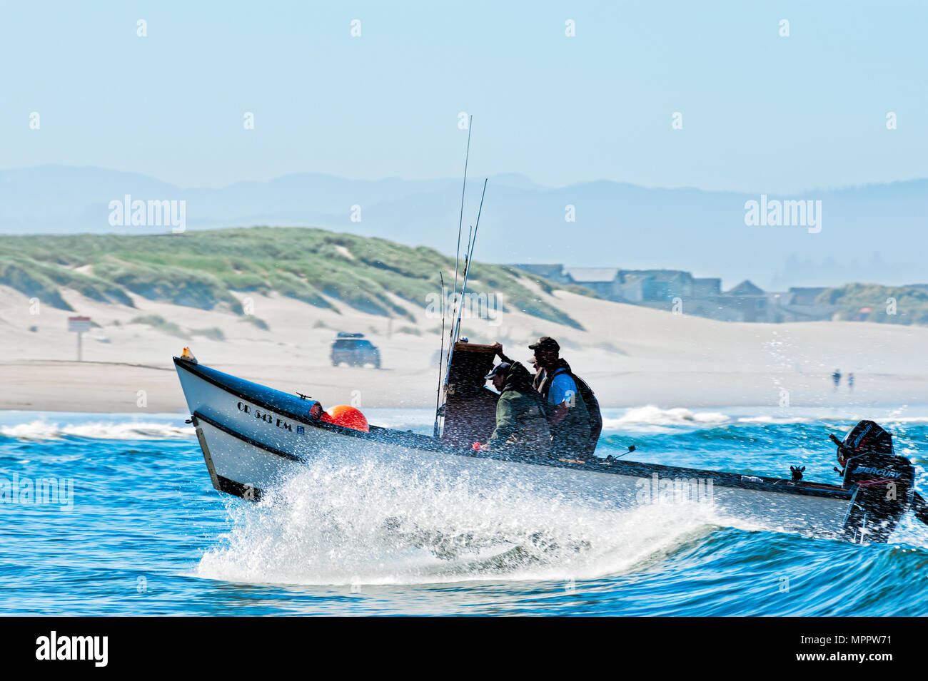 Pacific City, Oregon, USA - Juli 2, 2015: dory boat Kamm einer Welle wie er darauf abzielt, am Sandstrand von Cape Kiwanda in Pacific City, Oregon nach Land Stockfoto