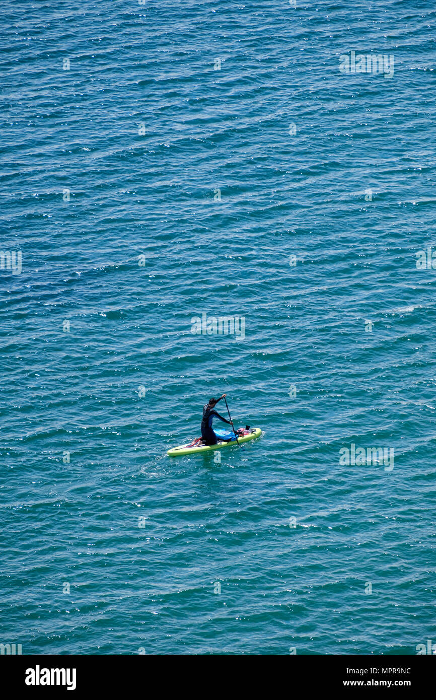 Mann in Anzug auf PADDLE BOARD AUF SEE, LYDSTEP PEMBROKESHIRE WALES UK Stockfoto