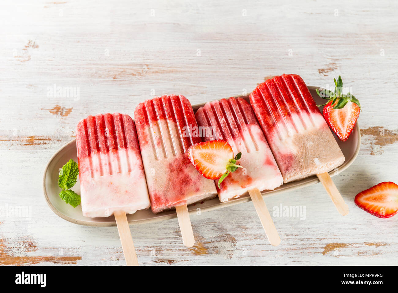 Hausgemachte Vegan Erdbeere Popsicle aus Erdbeersaft und Kokosmilch auf hellen Hintergrund. Sommer essen Konzept. Ansicht von oben. Stockfoto