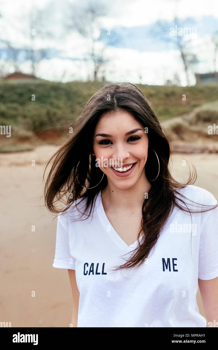 Porträt einer Lachen brünette Frau am Strand Stockfoto