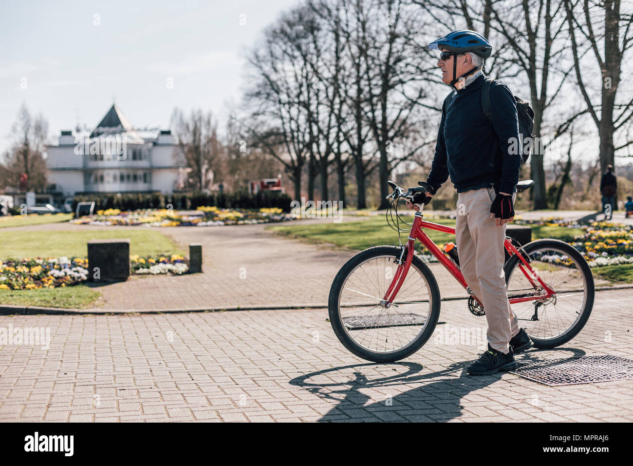 Älterer Mann mit Fahrrad in einem Park Stockfoto
