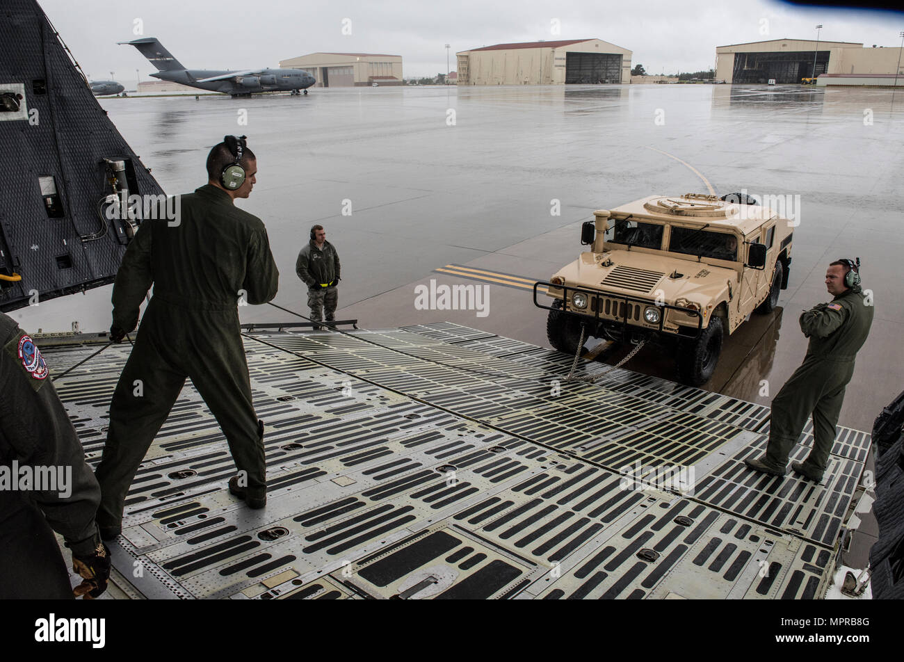 US Air Force Besatzungsmitglieder für die 22. Luftbrücke Geschwader arbeiten, um zu laden und sichern eine hohe Mobilität Mehrzweck Rädern Fahrzeug (HMMWV) in eine C5-M Super Galaxy Flugzeug während der Arbeiten mit Flieger-Programm, 7. April 2017. Das Programm beinhaltet Flügel Führung Interaktion mit Flieger zu bekommen einen detaillierten Überblick über jede Mission an Travis durchgeführt. (Foto der US Air Force / Heide Couch) Stockfoto
