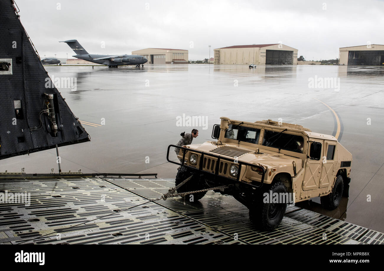US Air Force Besatzungsmitglieder für die 22. Luftbrücke Geschwader arbeiten, um zu laden und sichern eine hohe Mobilität Mehrzweck Rädern Fahrzeug (HMMWV) in eine C5-M Super Galaxy Flugzeug während der Arbeiten mit Flieger-Programm, 7. April 2017. Das Programm beinhaltet Flügel Führung Interaktion mit Flieger zu bekommen einen detaillierten Überblick über jede Mission an Travis durchgeführt. (Foto der US Air Force / Heide Couch) Stockfoto