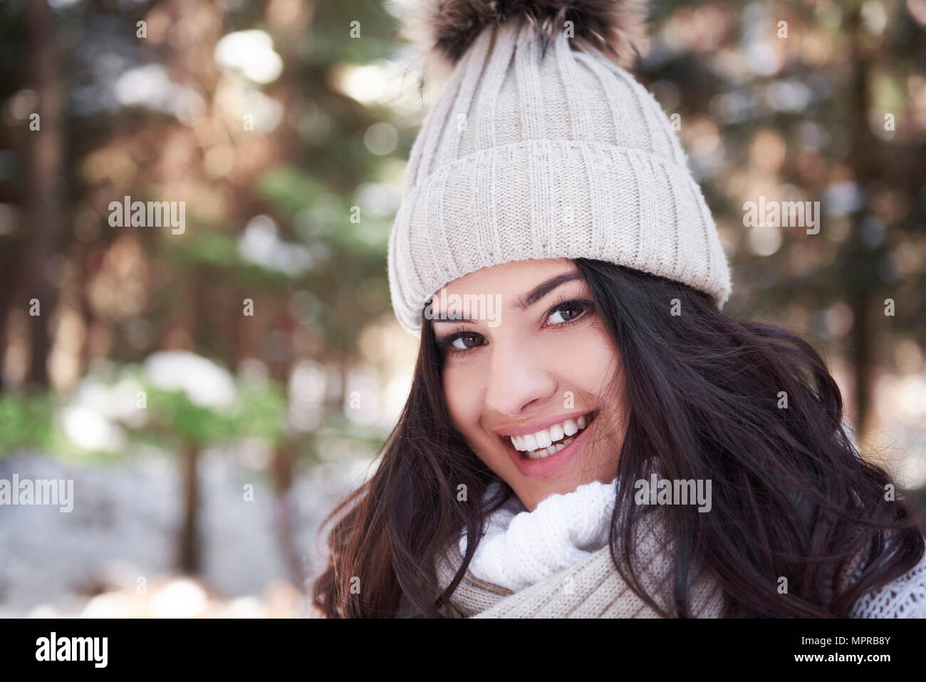 Portrait von lächelnden jungen Frau tragen Woolly Gap im Wald Stockfoto