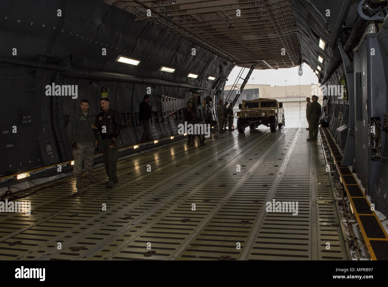 US Air Force Besatzungsmitglieder für die 22. Luftbrücke Geschwader arbeiten, um zu laden und sichern eine hohe Mobilität Mehrzweck Rädern Fahrzeug (HMMWV) in eine C5-M Super Galaxy Flugzeug während der Arbeiten mit Flieger-Programm, 7. April 2017. Das Programm beinhaltet Flügel Führung Interaktion mit Flieger zu bekommen einen detaillierten Überblick über jede Mission an Travis durchgeführt. (Foto der US Air Force / Heide Couch) Stockfoto