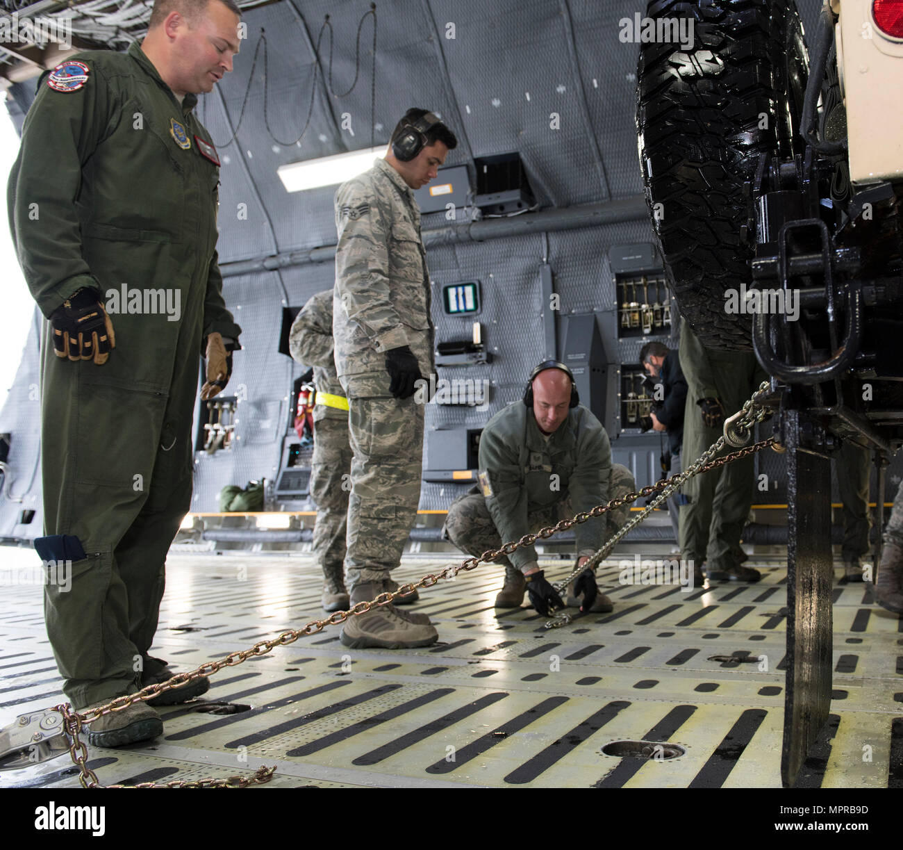 US Air Force Besatzungsmitglieder für die 22. Luftbrücke Geschwader arbeiten, um zu laden und sichern eine hohe Mobilität Mehrzweck Rädern Fahrzeug (HMMWV) in eine C5-M Super Galaxy Flugzeug während der Arbeiten mit Flieger-Programm, 7. April 2017. Das Programm beinhaltet Flügel Führung Interaktion mit Flieger zu bekommen einen detaillierten Überblick über jede Mission an Travis durchgeführt. (Foto der US Air Force / Heide Couch) Stockfoto
