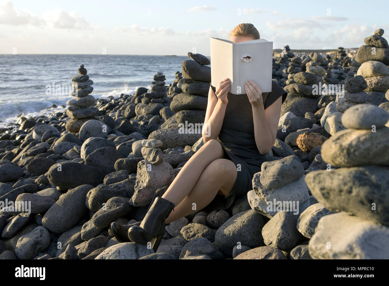 Frau mit Gesicht mit Buch, lesen Poesie, Auge durch die Abdeckung auf der Suche Stockfoto