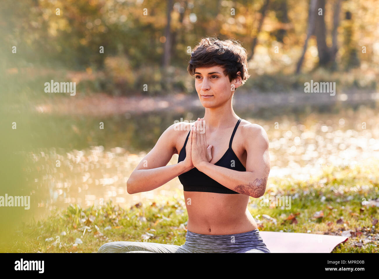 Mitte der erwachsenen Frau im Wald Üben Yoga, Meditation Stockfoto