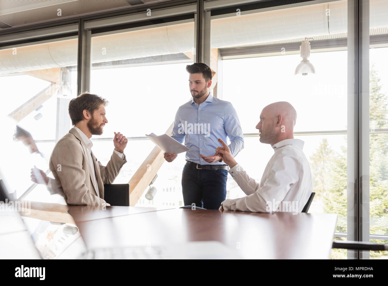 Drei Unternehmer diskutieren in Konferenzraum Stockfoto