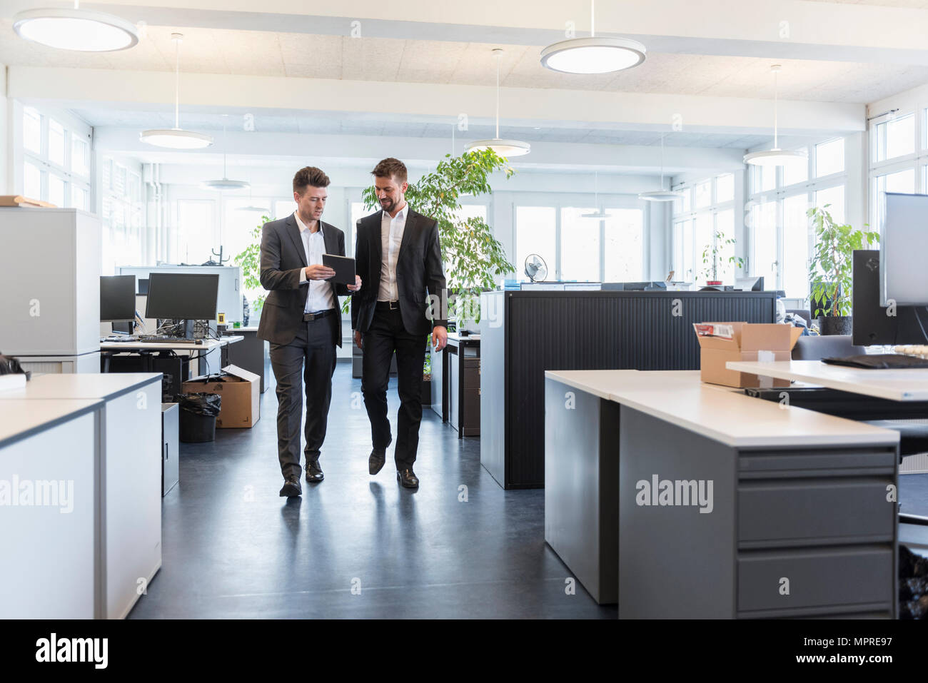 Zwei Geschäftsleute gehen in Büro, mit digitalen Tablet, Reden Stockfoto