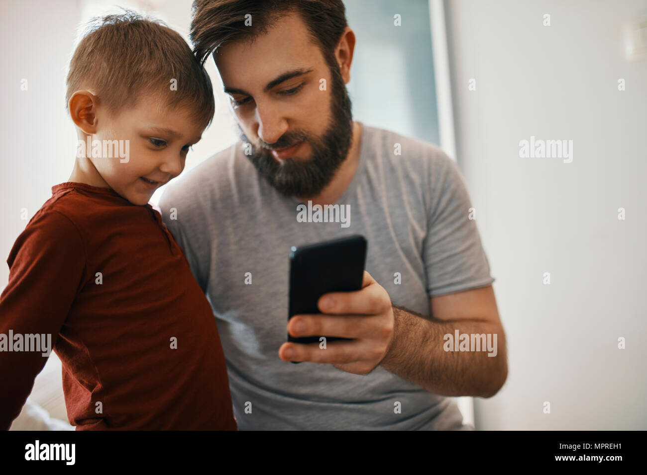 Vater erklären kleinen Sohn smartphone Stockfoto