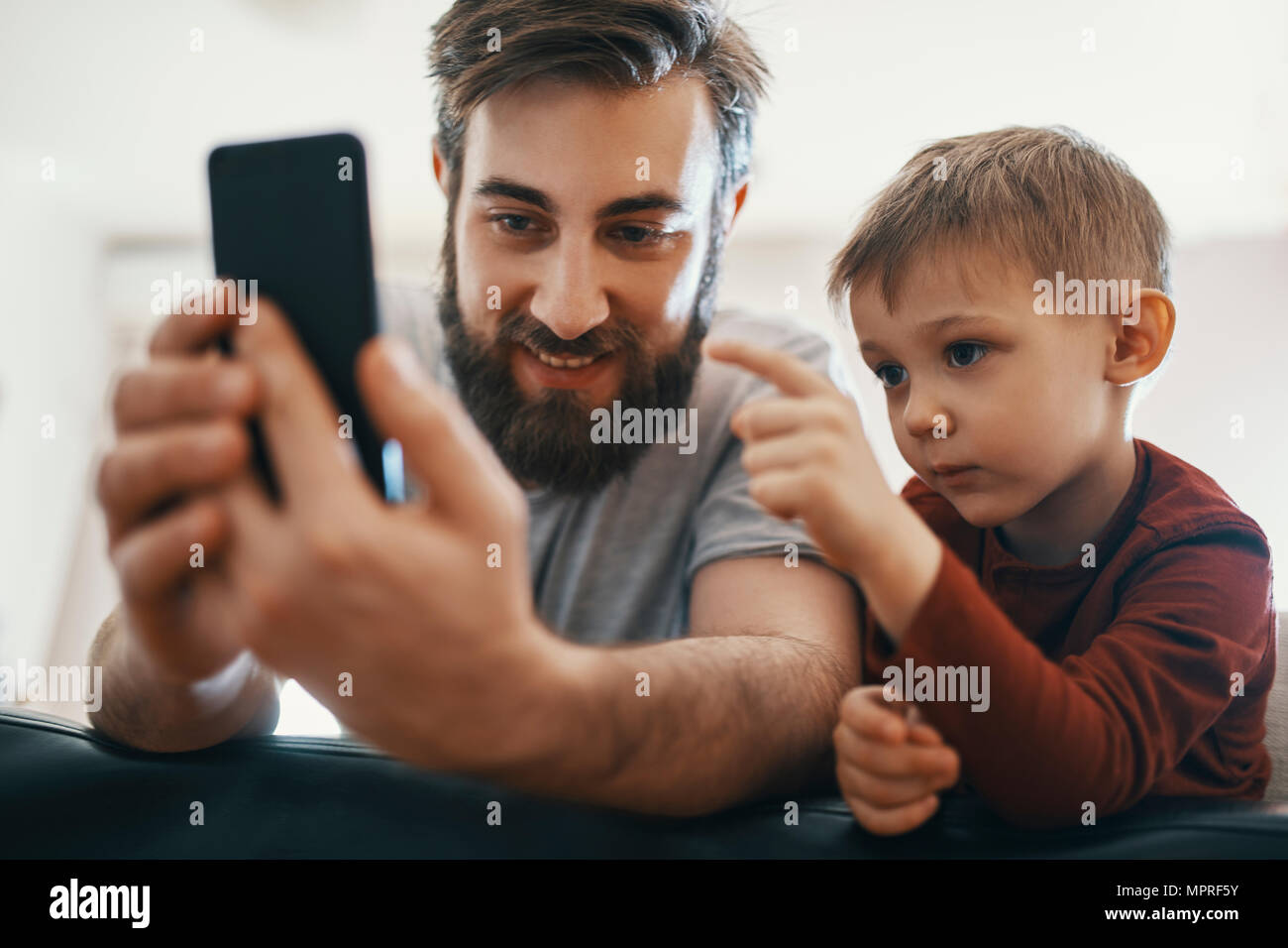 Portrait von Vater und Sohn mit Smartphone Stockfoto