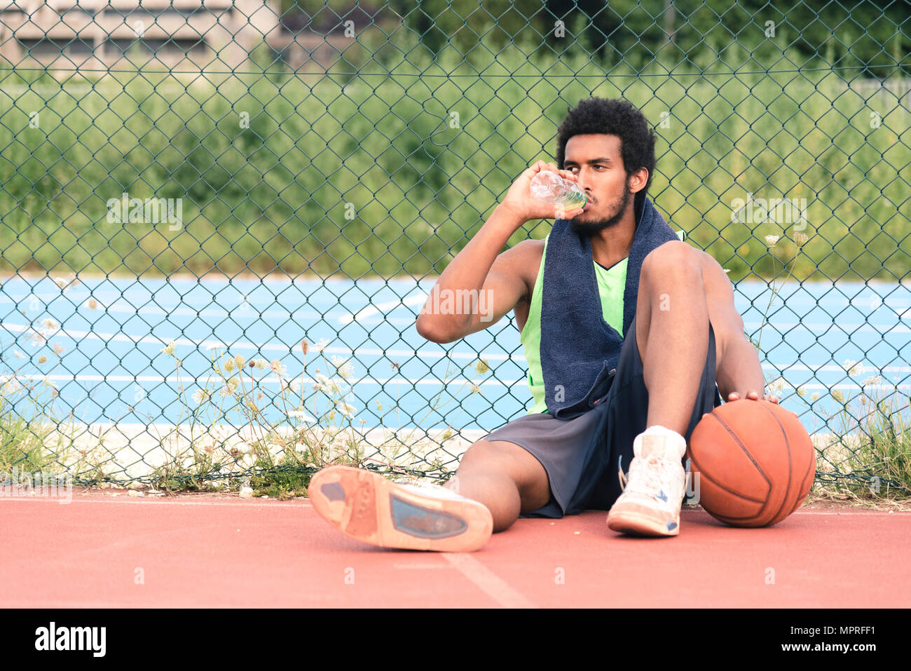 Junge Basketballspieler Trinken aus der Flasche Wasser Stockfoto