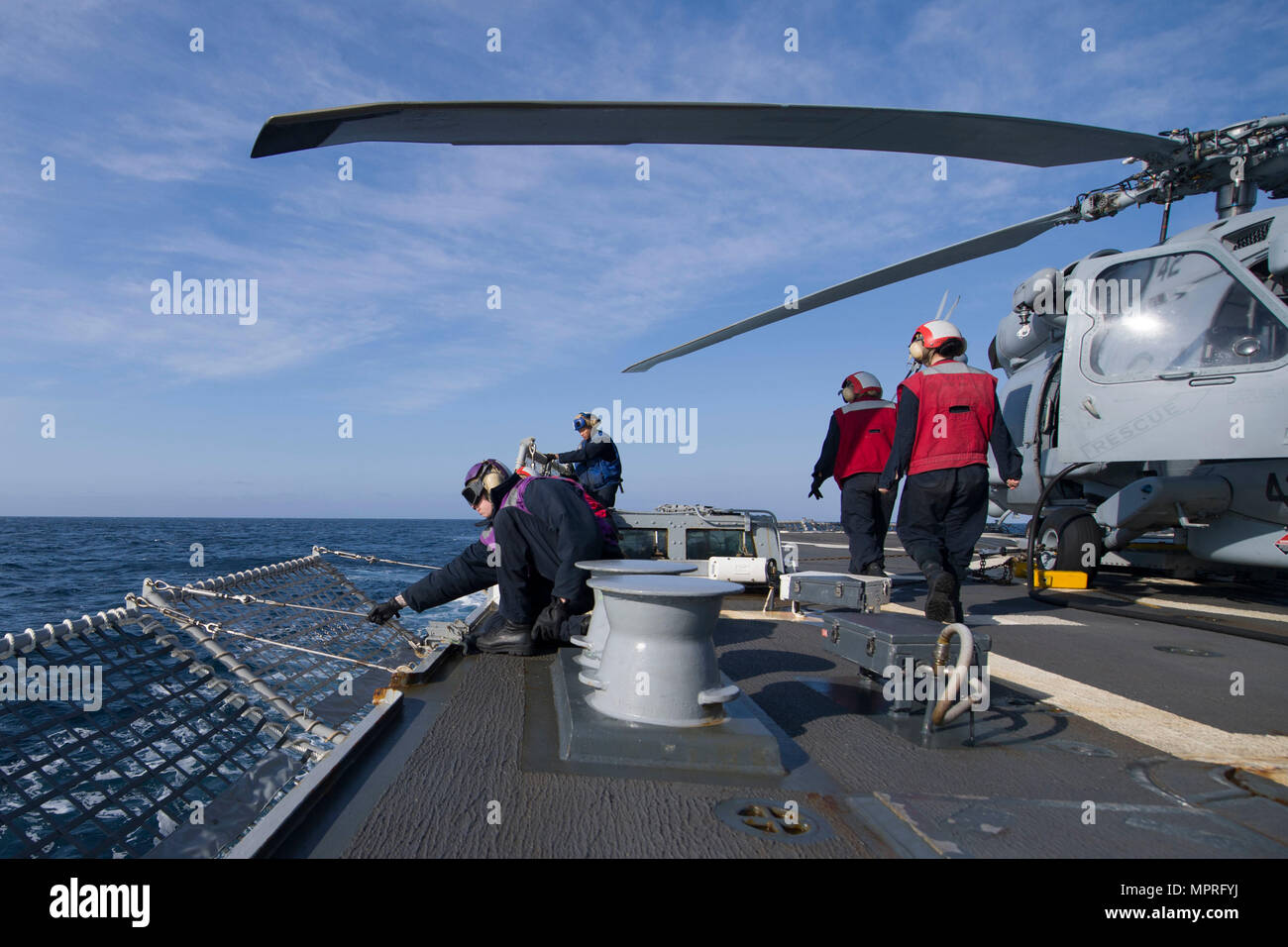 170411-N-BY095-013 Pazifik (11. April 2017) Seeleute an Bord der Arleigh-Burke-Klasse geführte Flugkörper Zerstörer USS Shoup (DDG 86) senken Flugdeck Sicherheitsnetze in Vorbereitung für den Flugbetrieb während im Gange für eine zusammengesetzte Einheit Übung (COMPTUEX) mit der Nimitz Carrier Strike Group in Vorbereitung auf eine bevorstehende Bereitstellung. COMPTUEX testet die Mission Bereitschaft der aktiven Streik durch simulierte reale Szenarien und ihre Leistungsfähigkeit als integrierte Einheit. (Foto: U.S. Navy Mass Communication Specialist 3. Klasse Maria I. Alvarez/freigegeben) Stockfoto