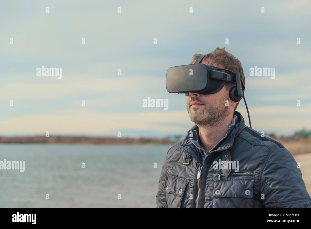 Mann mit VR-Brille am Seeufer Stockfoto