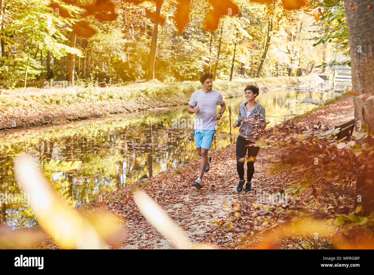 Paar Jogging auf autumnally Waldweg Stockfoto