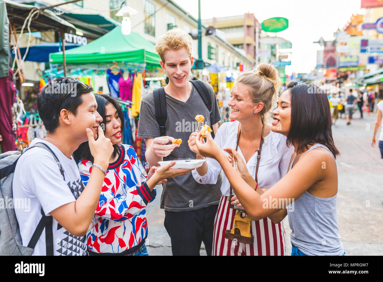 Thailand, Bangkok, Khao San Road, Gruppe von Freunden Verkostung lokaler Lebensmittel auf der Straße Markt Stockfoto