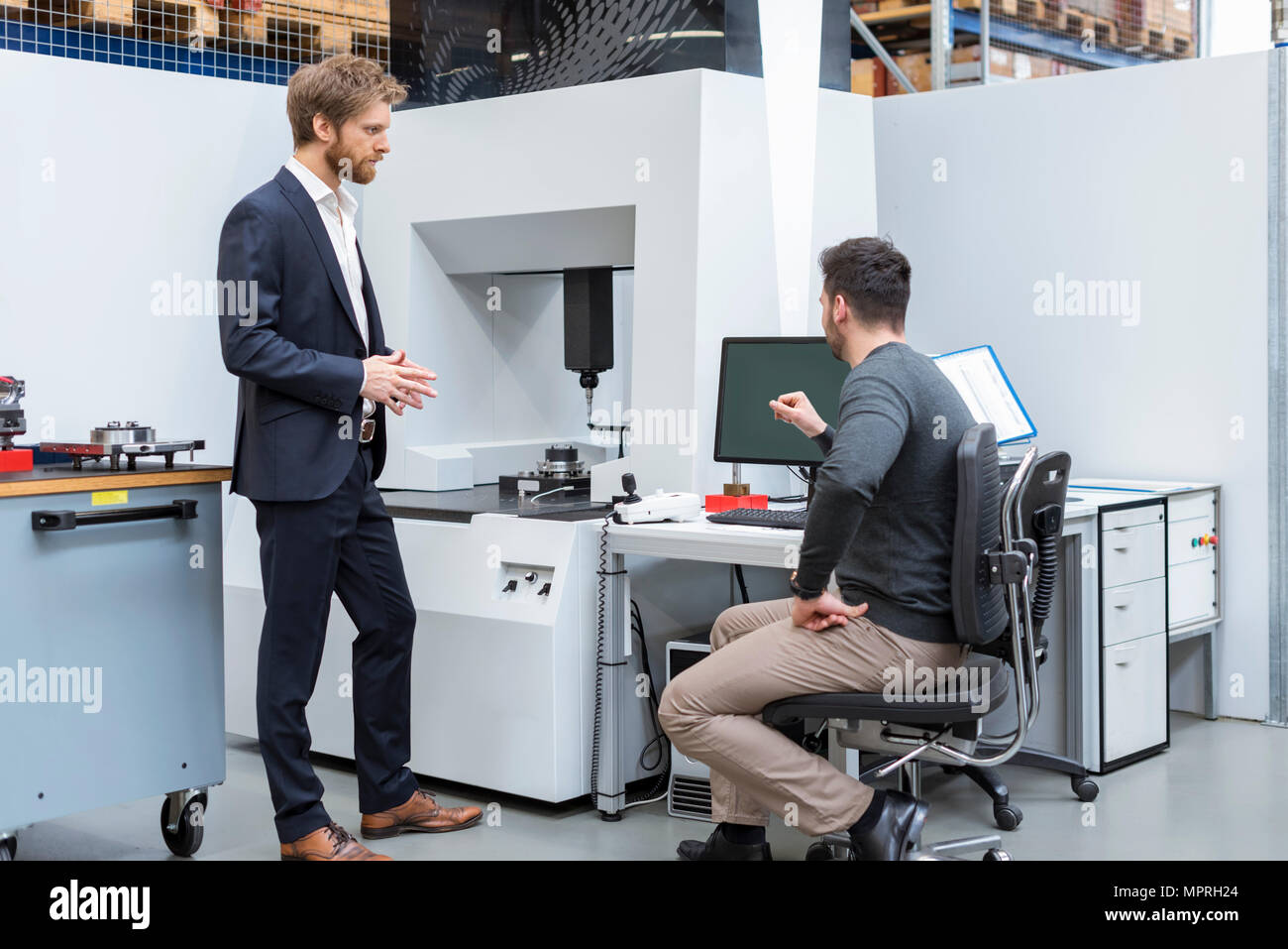 Zwei Männer, die an der Maschine in der modernen Fabrik Stockfoto