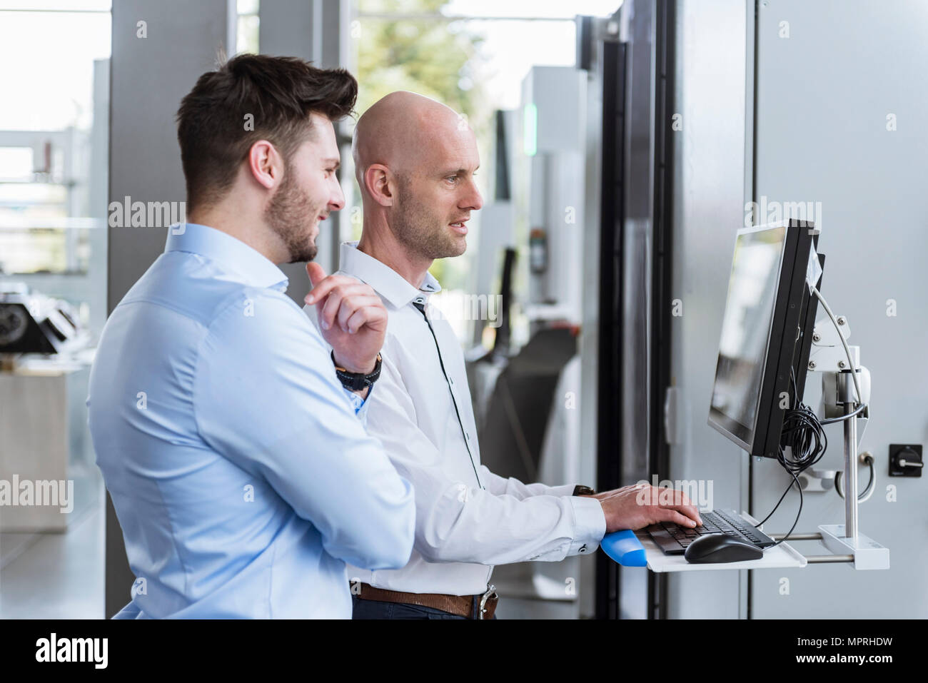 Zwei Geschäftsleute in Unternehmen sprechen, am Computer Stockfoto