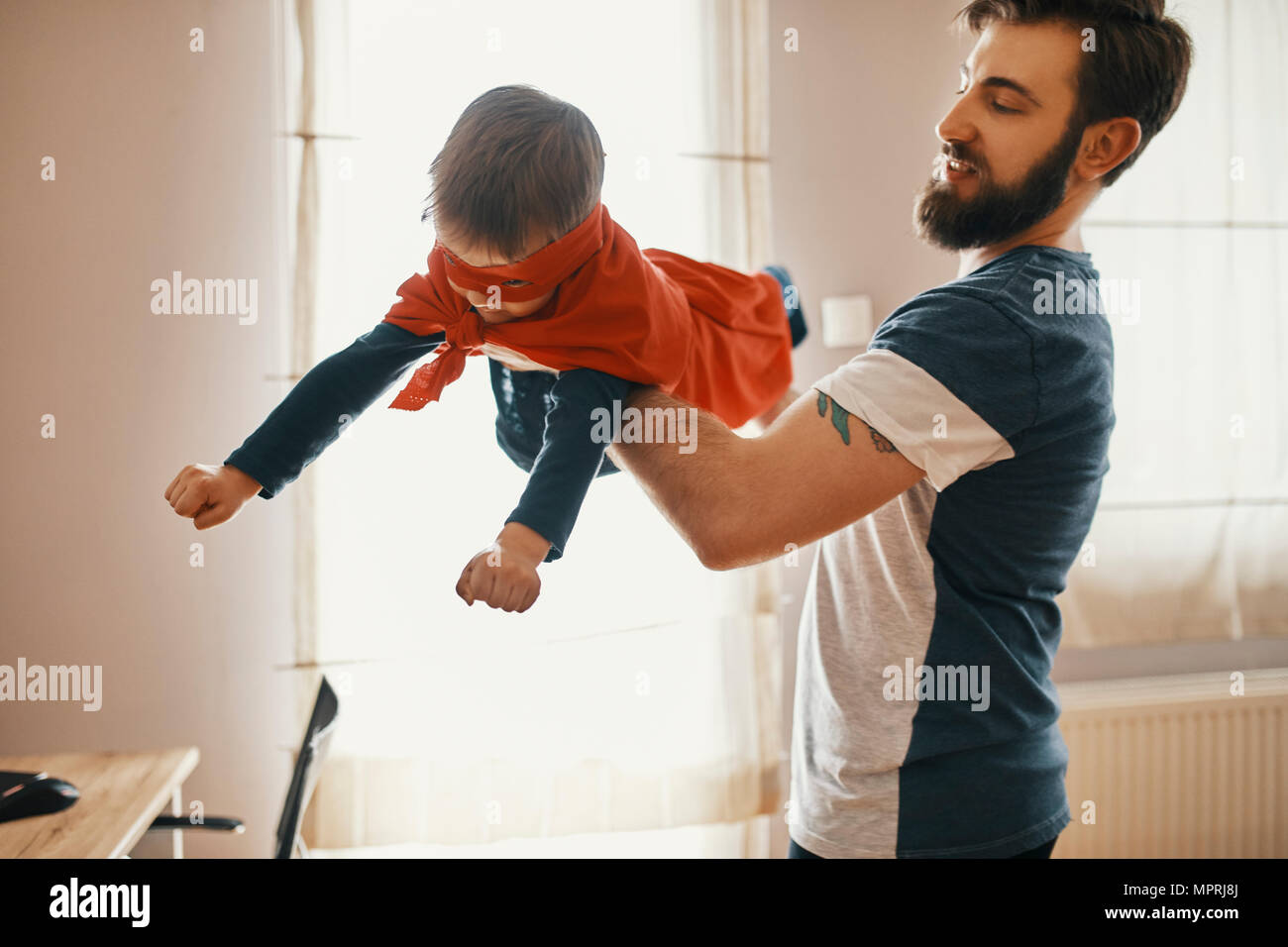 Vater mit seinem kleinen Sohn als Superheld gekleidet Stockfoto