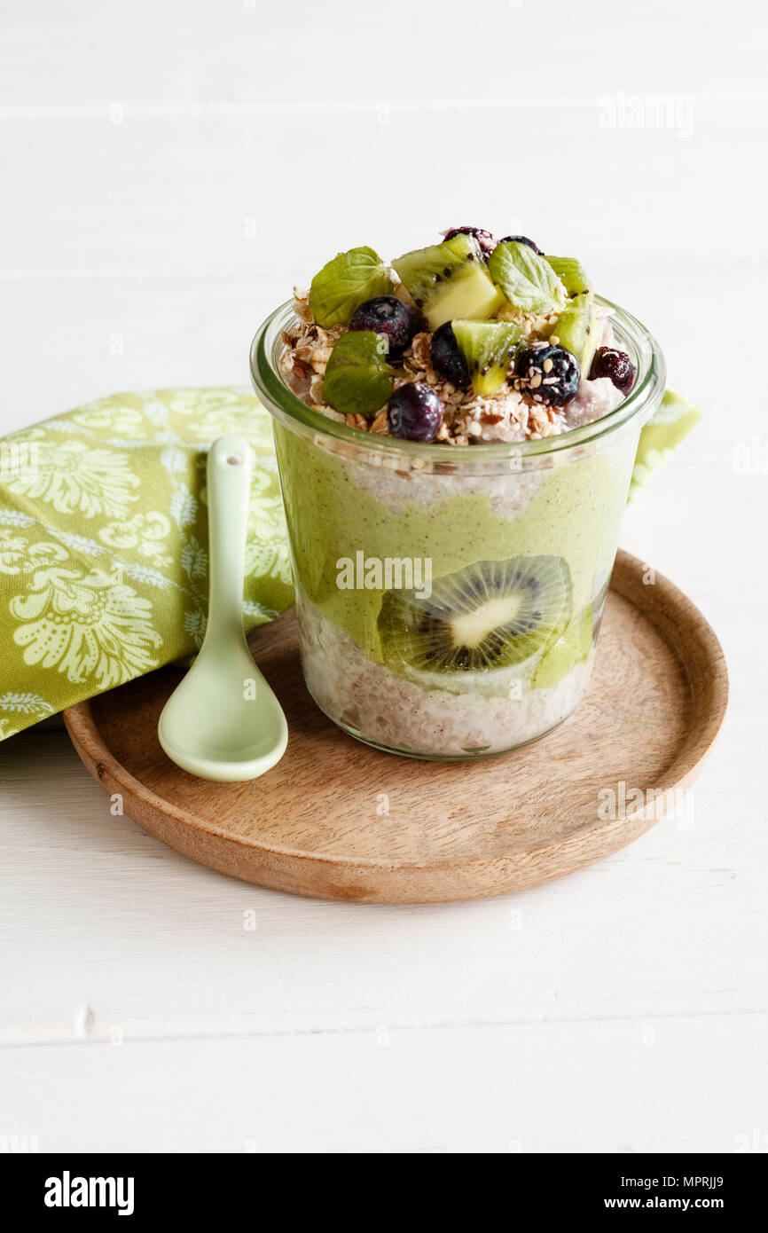 Glas von Chia Pudding mit Kiwi, Beeren, Müsli und Kale Smoothie Stockfoto