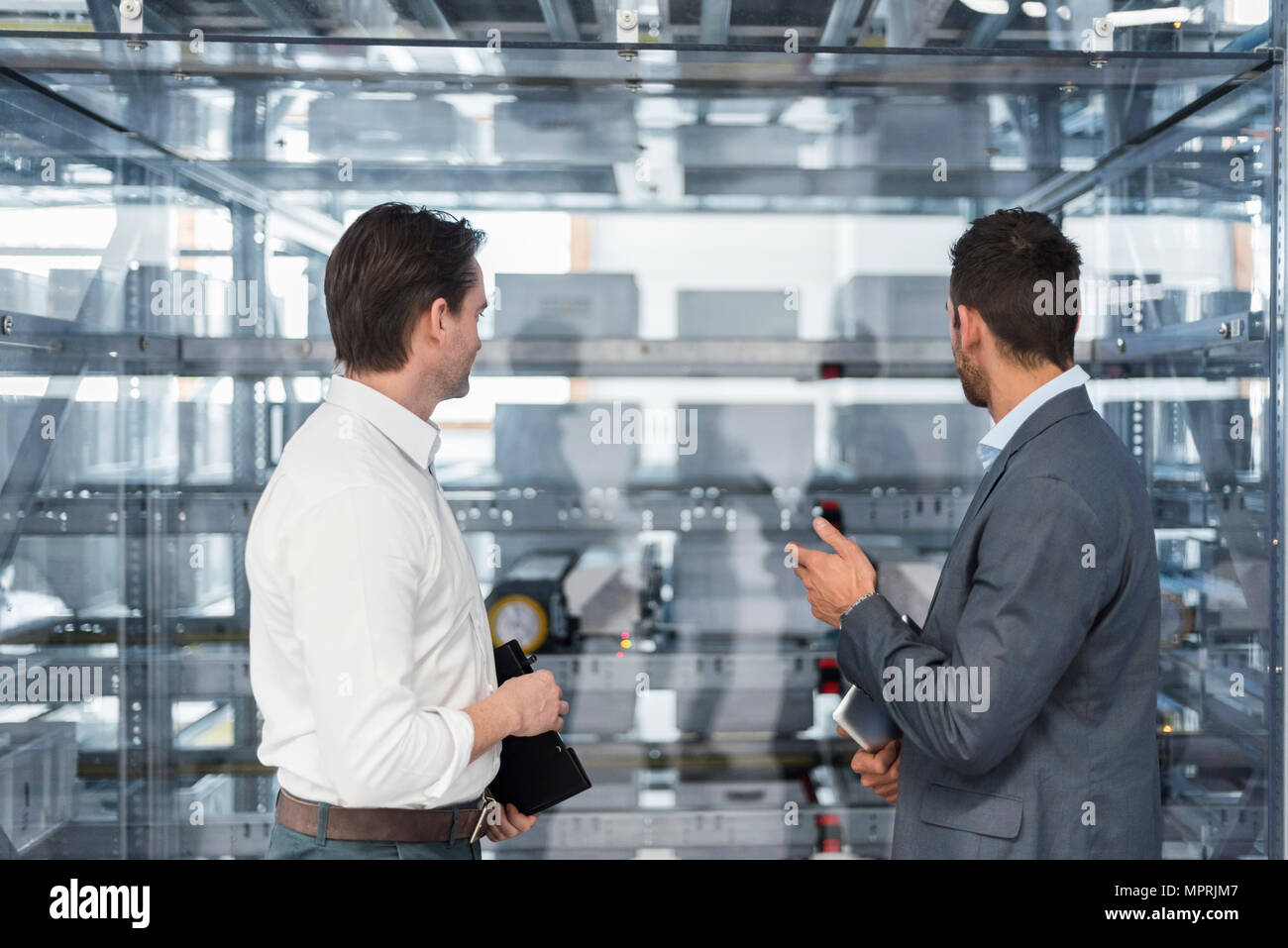Zwei Geschäftsleute sprechen in der modernen Fabrik Stockfoto