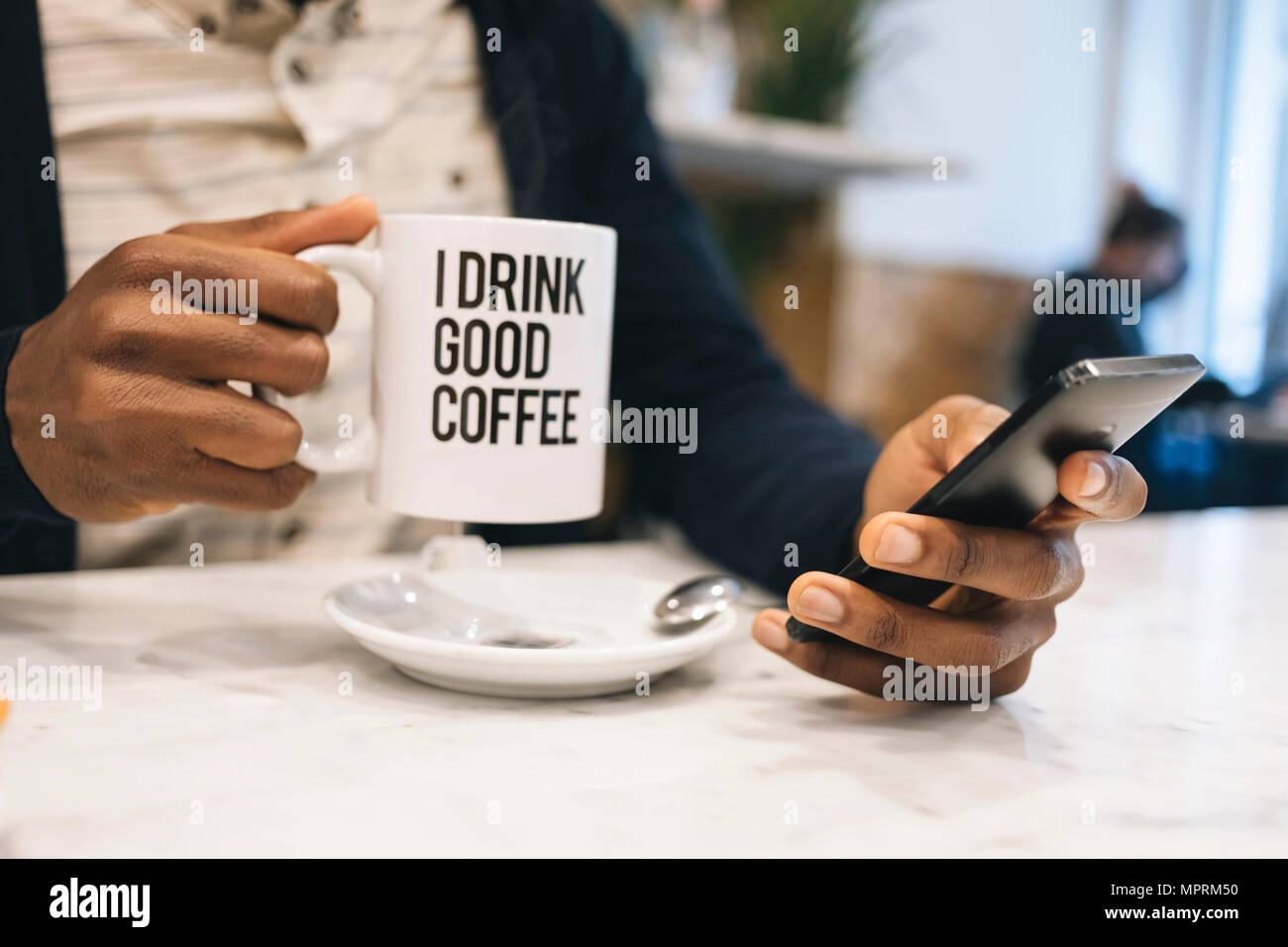 Nahaufnahme der Mann mit Tasse Kaffee in einem Cafe mit Handy Stockfoto