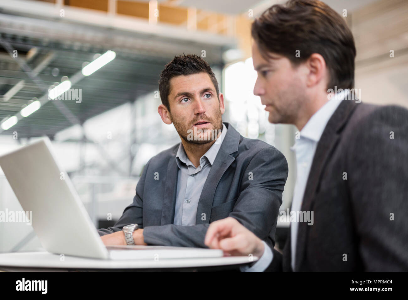 Zwei Geschäftsleute teilen Laptop in der Factory Stockfoto