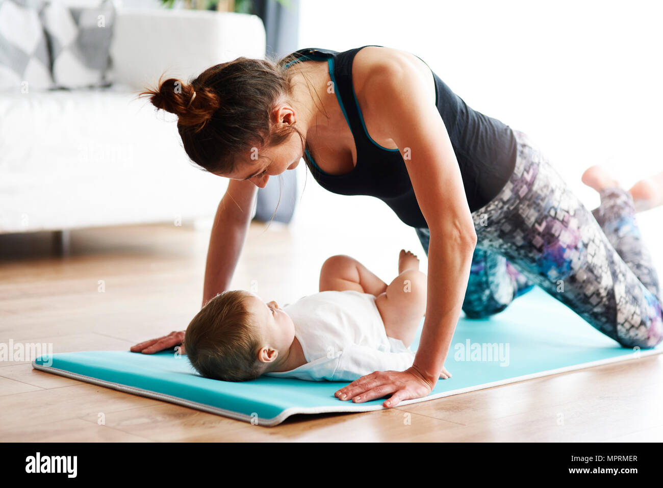 Mutter mit Baby der Ausübung von Yoga Matte zu Hause Stockfoto