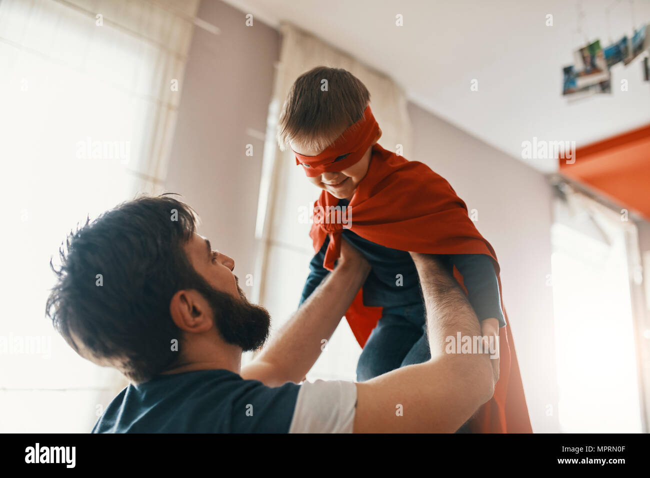 Vater mit seinem kleinen Sohn als Superheld gekleidet Stockfoto
