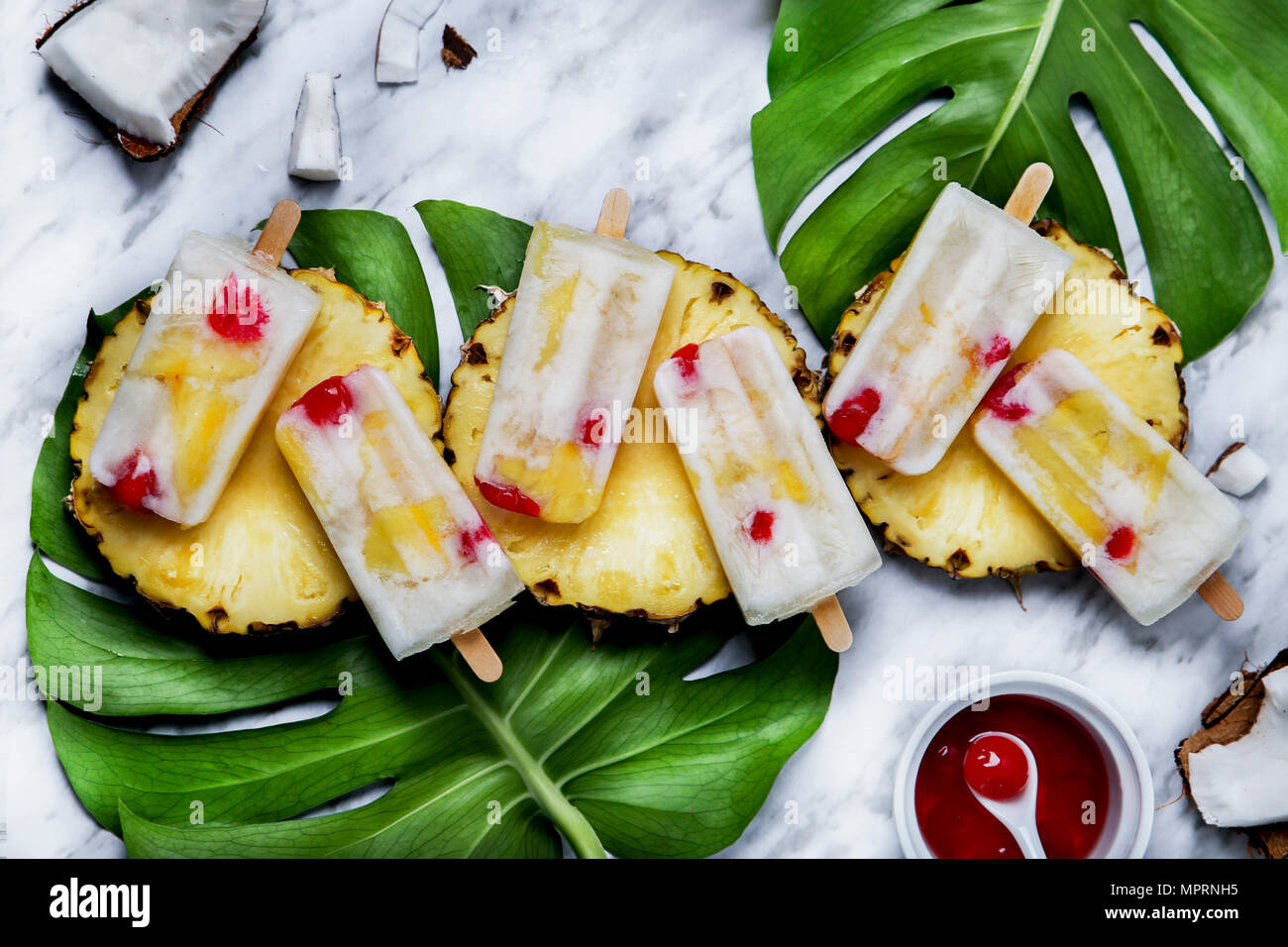Pina Colada Eis am Stiel mit kandierten Kirschen und Ananas Stockfoto