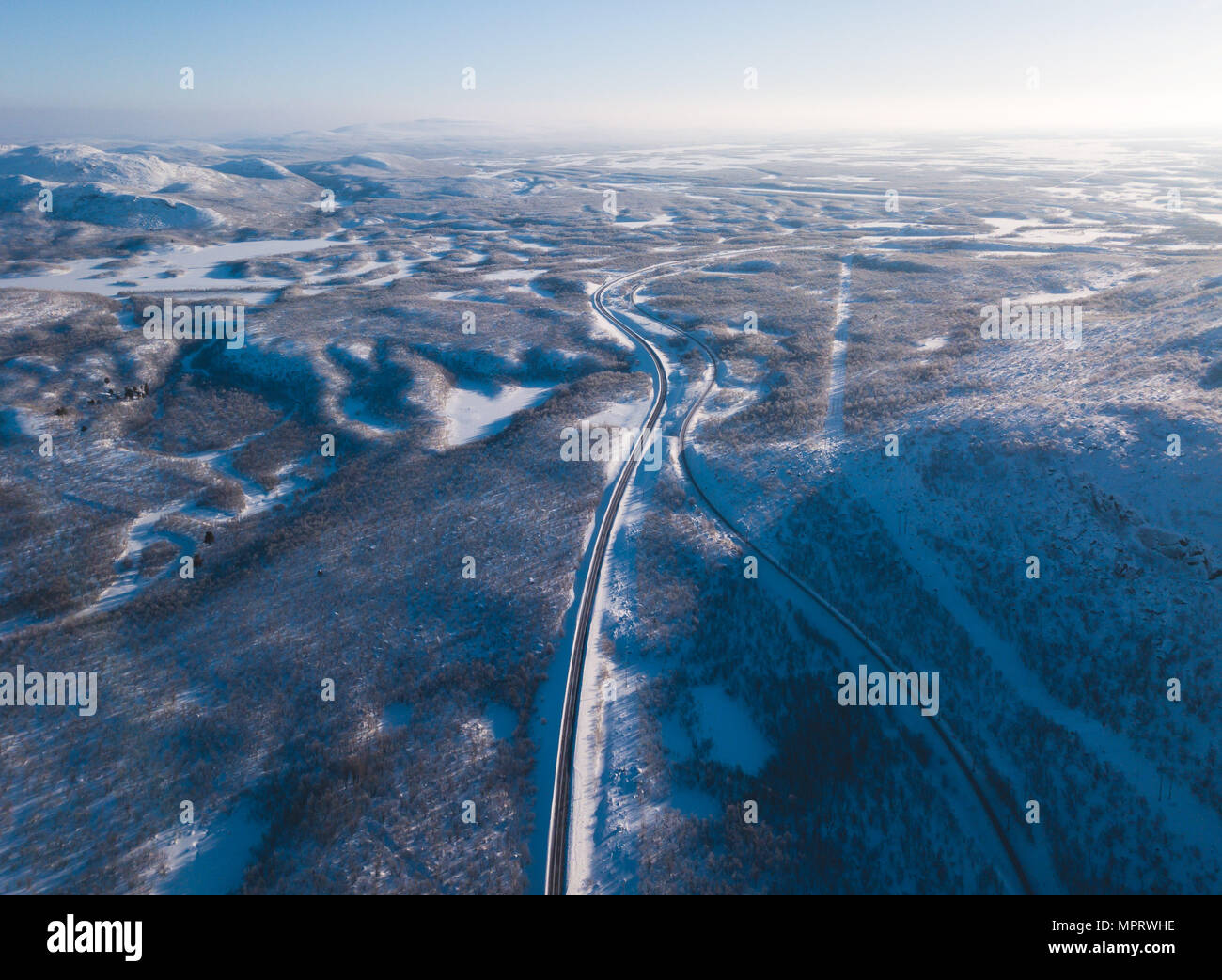 Antenne sonnigen Winter Blick auf Abisko Nationalpark, Gemeinde Kiruna, Lappland, Norrbotten County, Schweden, geschossen von Drohne, mit Straßen und Berge Stockfoto