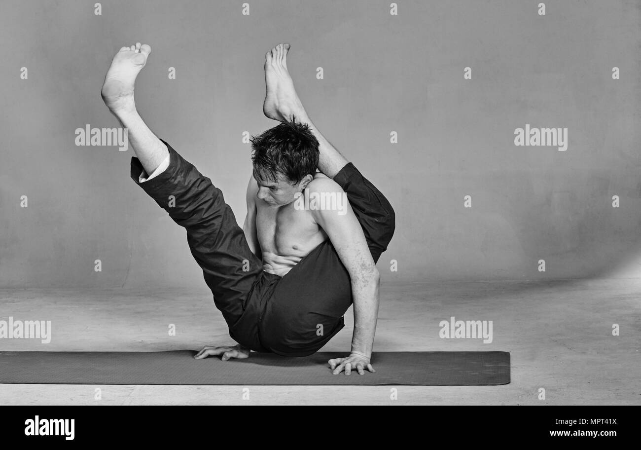 Ein junger Mann ist im Yoga in einem Studio eingerückt Stockfoto