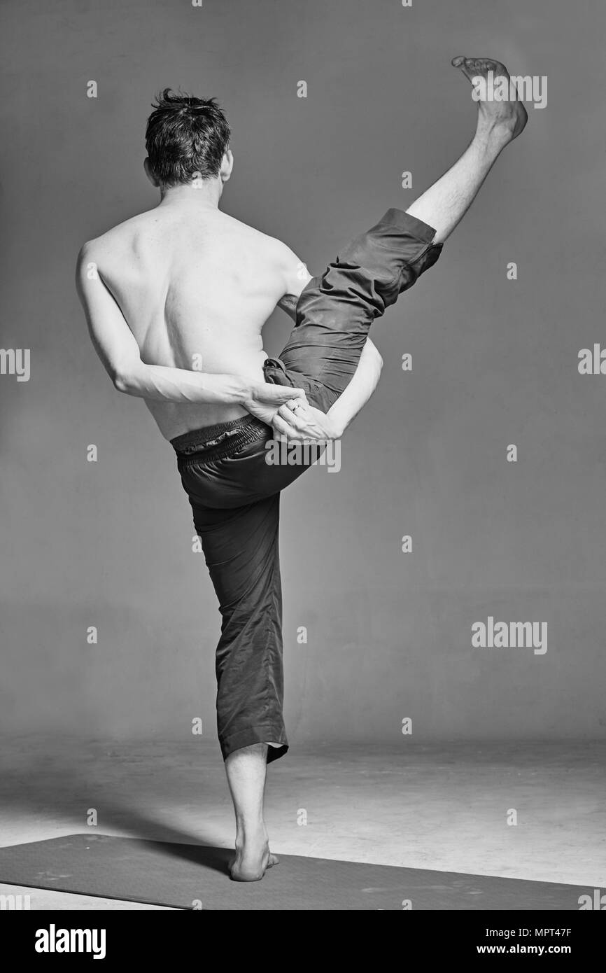 Ein junger Mann ist im Yoga in einem Studio eingerückt Stockfoto