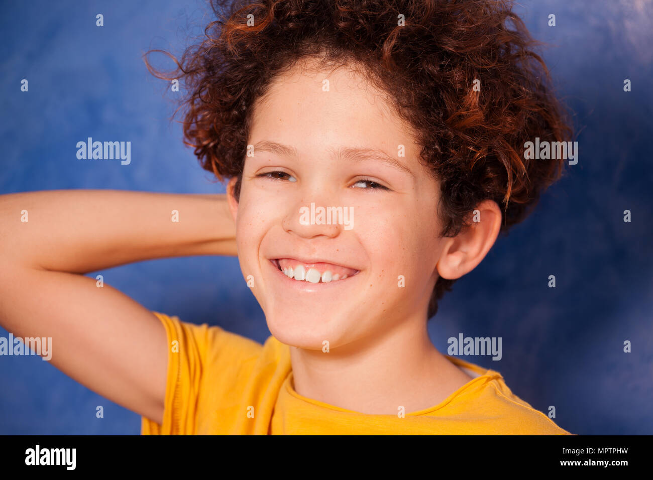 Close-up Portrait von Jugendlichen curly Boy lachen und auf der Suche an Kamera Stockfoto