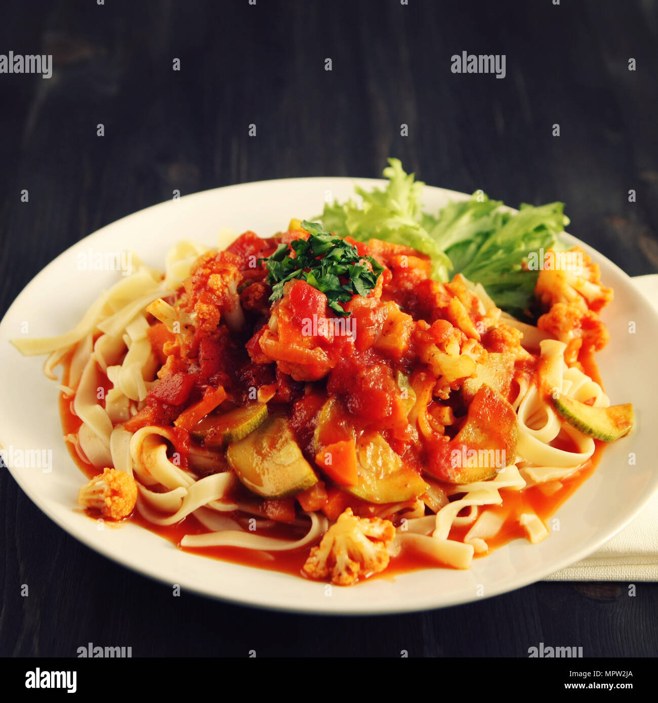 Ribbon Pasta mit Sauce Arrabiata. Close Up. Mittelmeer Teller. Tagliolini Nudeln mit Gemüse. Blumenkohl, Zucchini und Tomate Eintopf. Italienische cui Stockfoto