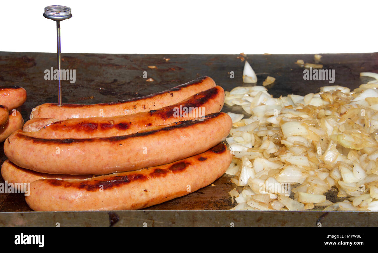 Große Hot Dog Würstchen grillen Neben gehackte Zwiebeln auf einem im BBQ-Grill. Thermometer in Fleisch. Street Hersteller Grill mit weißem Hintergrund Stockfoto