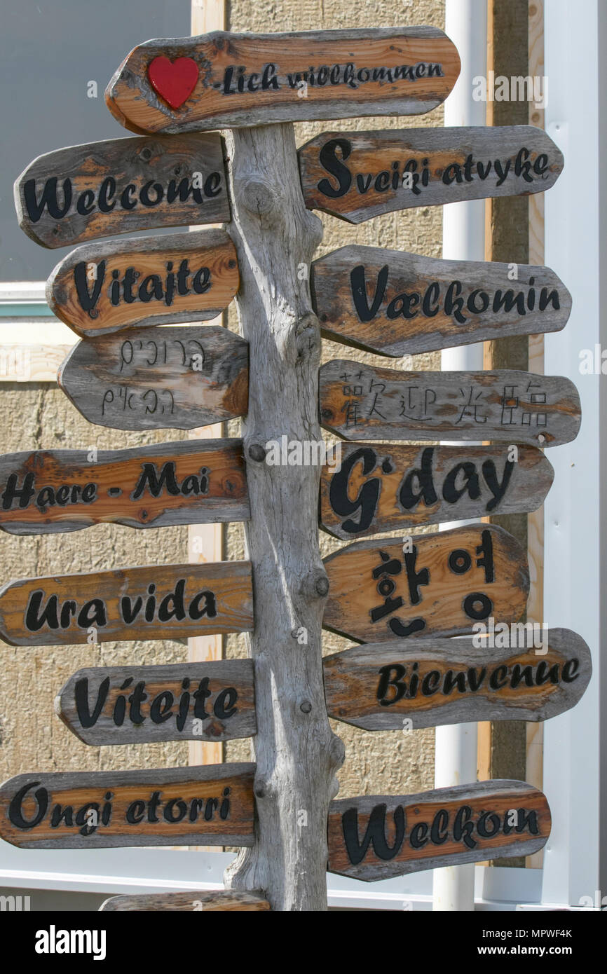 Neugierig rustikalen hölzernen hausgemachten Gruß, freundlich, bunte Willkommensschilder übersetzt europäischen internationalen verschiedenen Sprachen, Djupivogur, Island. Stockfoto