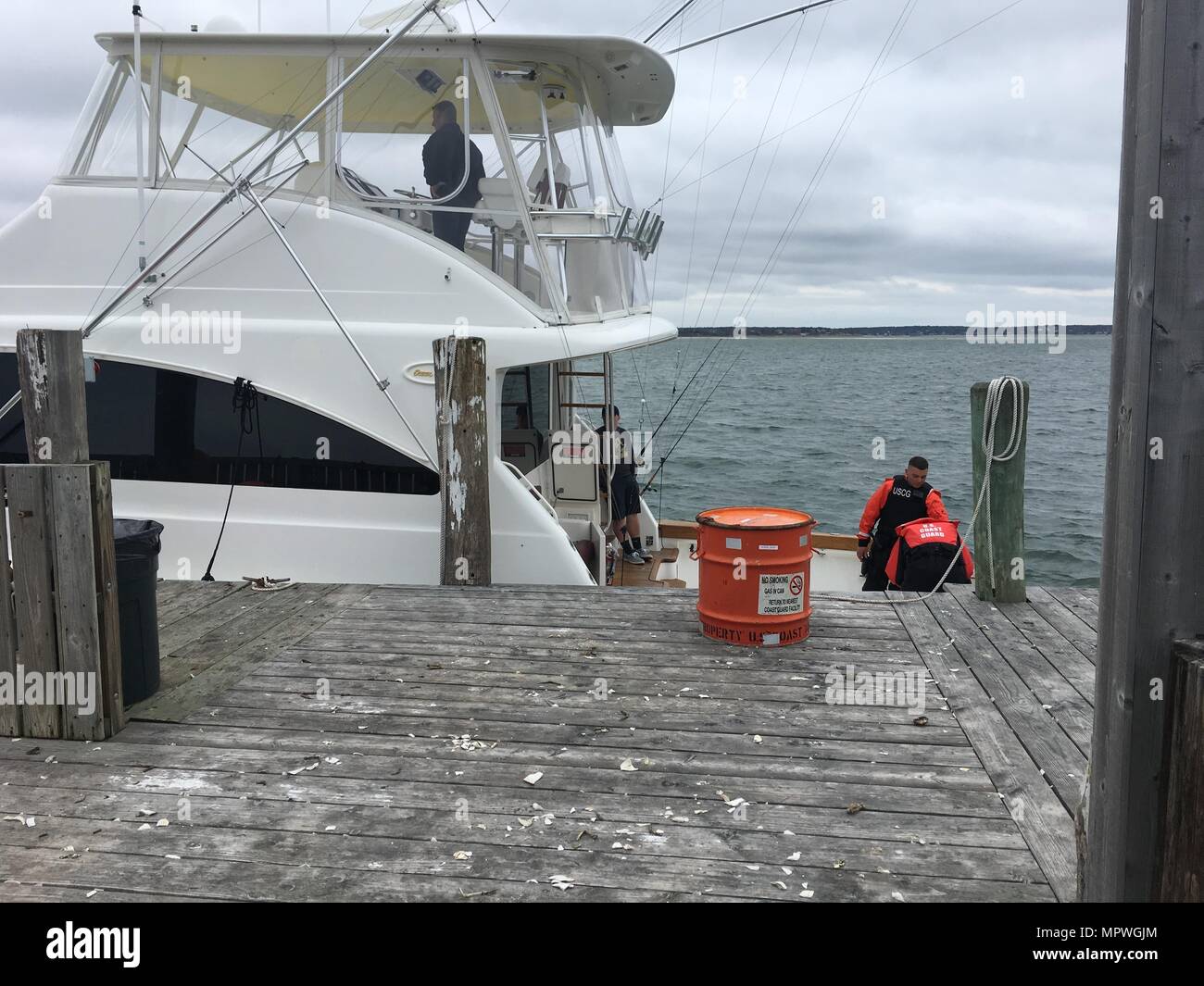 Zwei Besatzungsmitglieder der Coast Guard Station Shinnecock führen eine Stelle Suche und Rettung Verpflegung an Bord Kristen Lynn, ein 54-Fuß Sportboot Samstag, 22. April 2017, Oaklands Marina in Hampton Bays, New York. Eine Station Shinnecock Boatcrew unterstützt die Kristen Lynn nach Bekanntwerden, dass Kristen Lynn auf Wasser in der Nähe von Shinnecock Inlet hergestellt wurde. (Foto: U.S. Coast Guard Petty Officer 2. Klasse Christopher Geiser) Stockfoto