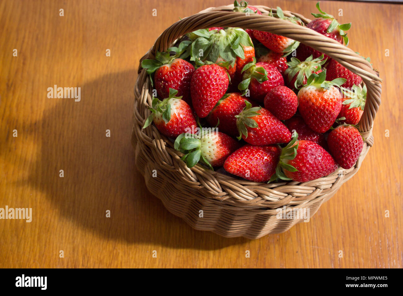 Die frische Erdbeeren in einem Korb in den Vorstand. Stockfoto