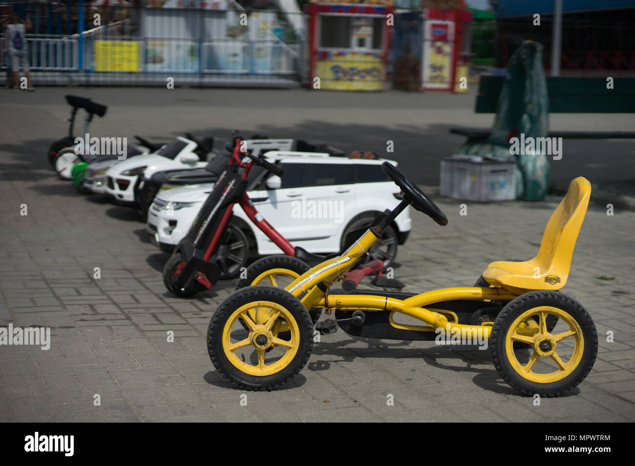 Autos mit Pedalen für Kinder stehen in einer Reihe Stockfoto