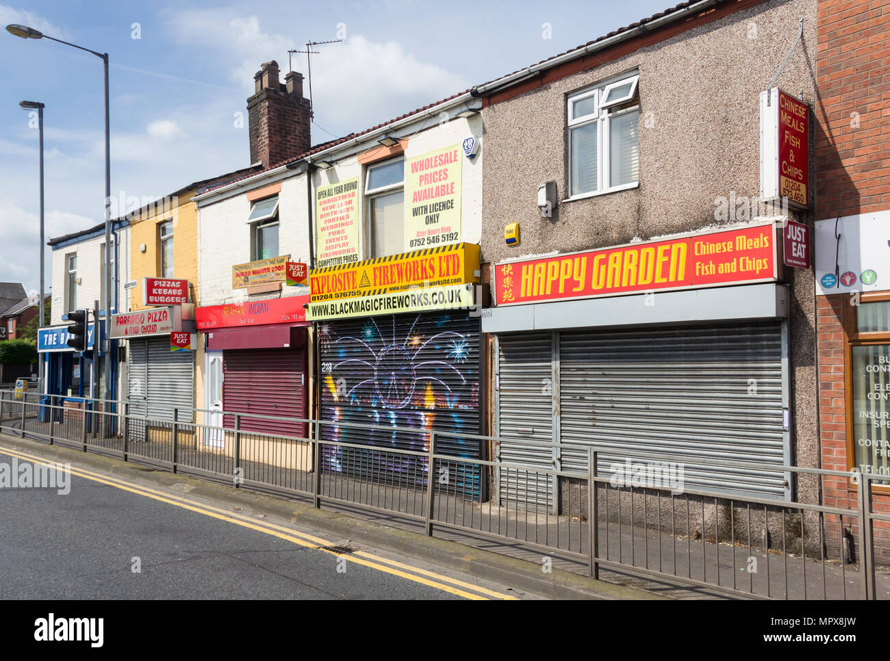 Reihe der geschlossene Geschäfte im Albert Road, Farnworth. Drei der Geschäfte sind takaway Restaurants (Chinesische, Indische und Pizza zum Mitnehmen). Stockfoto