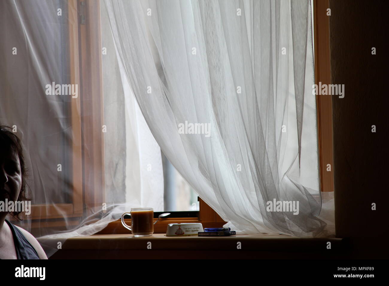 Frau sitzt am Fenster und rauchen Zigaretten, Polen Danzig. Stockfoto