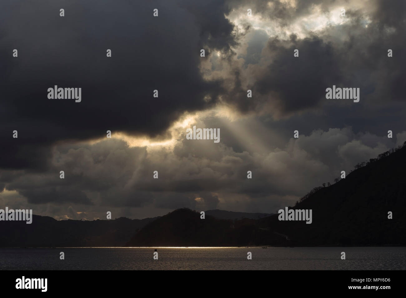 Malerischer Blick auf Meer von Silhouette Berge gegen bewölkter Himmel bei Sonnenaufgang Stockfoto