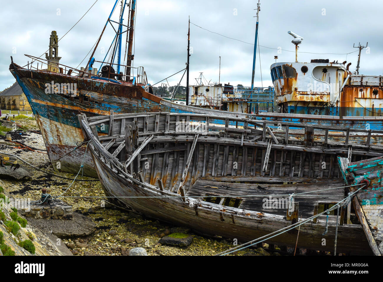 Zerbröckelnde Schiffe mit abblätternder Farbe und verrottete Strukturen im Boot Friedhof in Camaret-sur-Mer im Département Finistère in der Bretagne, Frankreich. Stockfoto